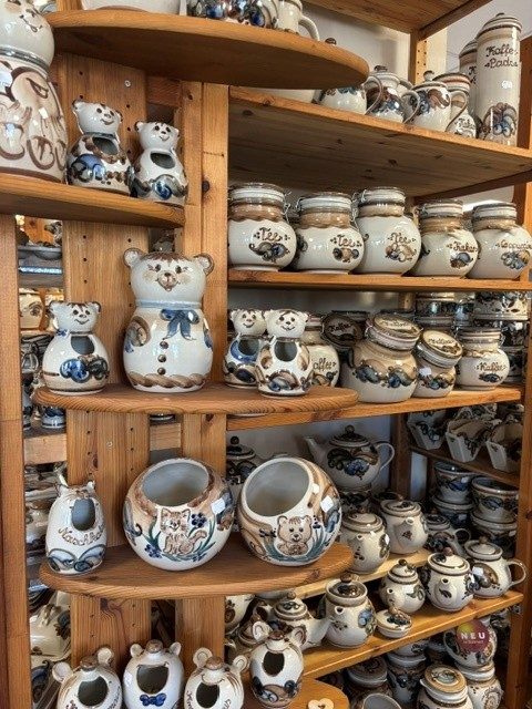 Holzregale mit blau bemalten Vorratsdosen und Tierfiguren aus Keramik